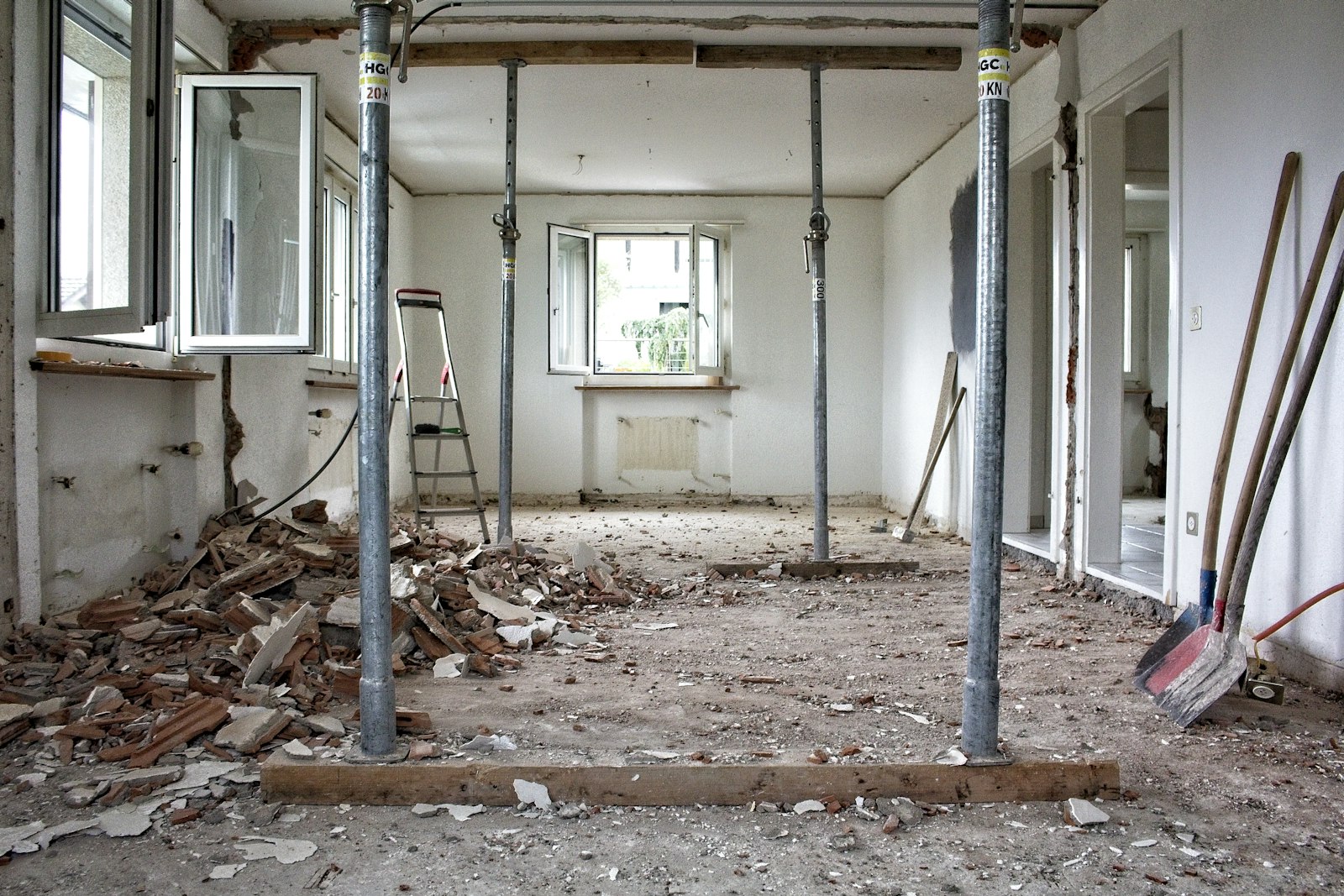 Vivienda en obra con puntales metálicos, escombros y escalera de tijera