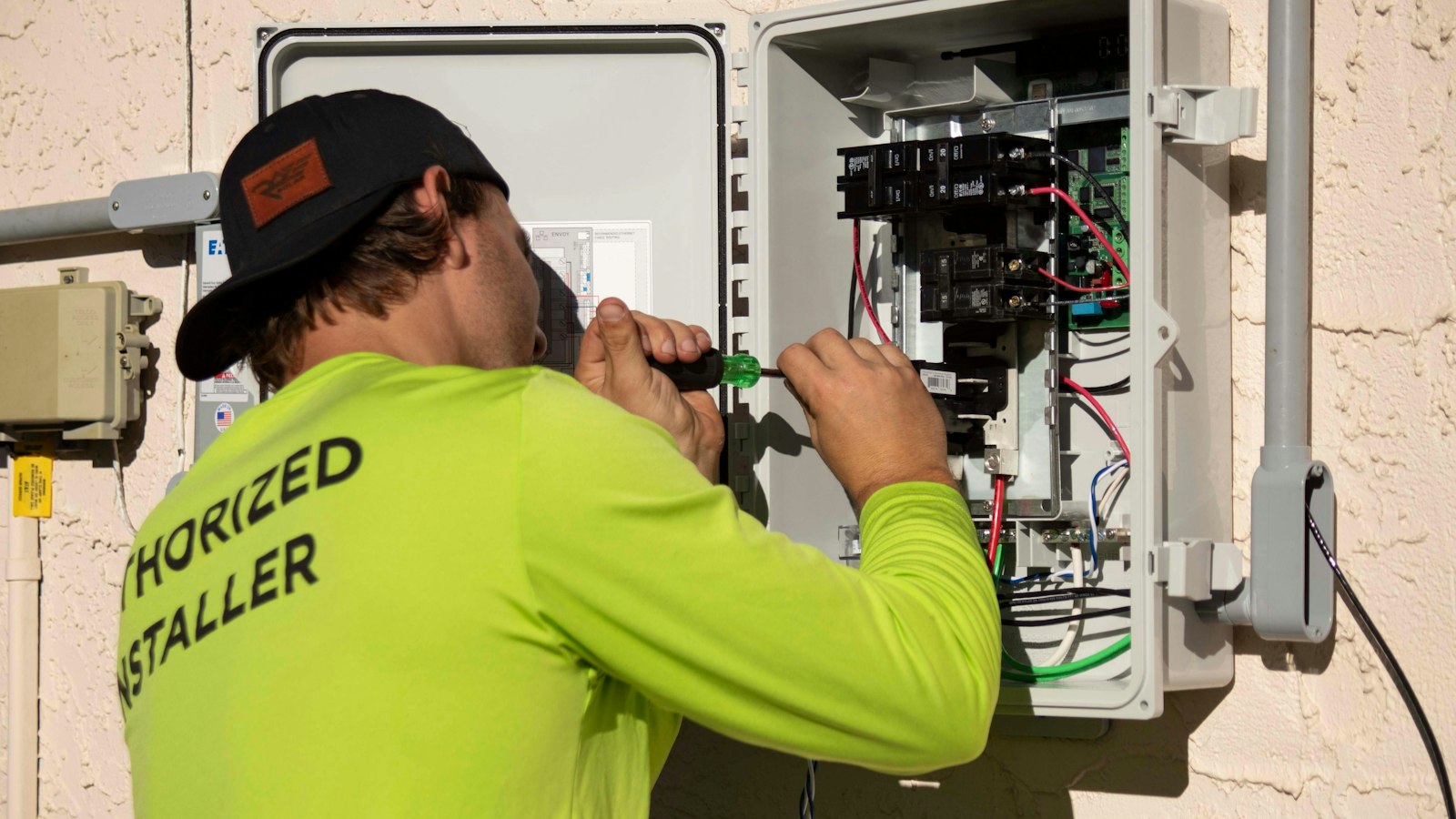 Electricista conectando un cuadro eléctrico con un destornillador